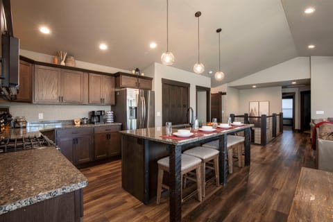 Imagine gathering in the bright open-plan space at "On The Rocks," lounging on the plush sofa, sharing meals at the dining table, or chatting at the granite island bar.