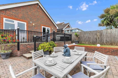 Well-kept back garden with open lawn and patio area, perfect for outdoor dining or stargazing.