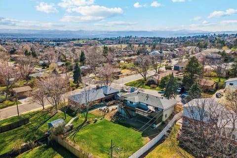 Aerial view of backside of house. Large grassy yard, upper deck, covered patio