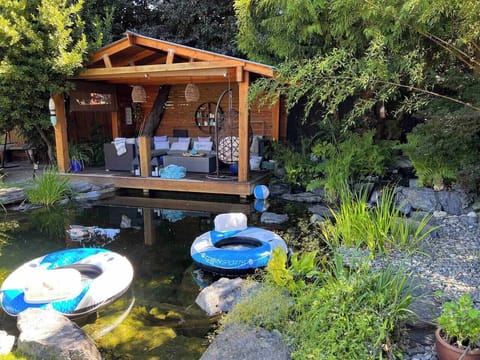 Backyard oasis with swim pond, dock and firetable.