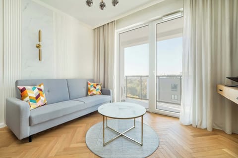 Air conditioned living room with television, coffee table, single sofa bed, dining area and kitchenette.