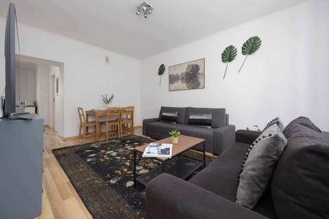 Living area with two sofas, TV and dining area.
