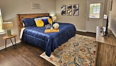 Relax in this farmhouse-style bedroom. There is a king bed along with a flat-screen smart TV. Step out the door to the back patio and fenced-in backyard.