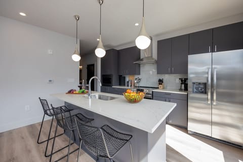 Unit 1: Fully equipped kitchen stocked with basic cooking essentials. Includes stainless steel appliances and kitchen island seating.