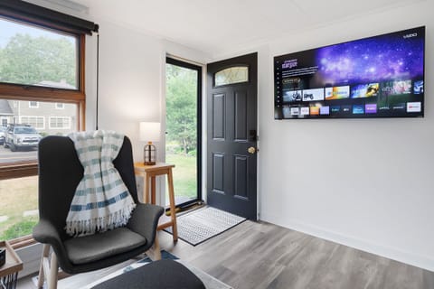 Step into an open-concept living room and kitchen with a smart TV.