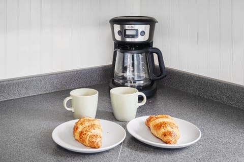 A drip coffee machine, filters, coffee, sugar and cream are provided.