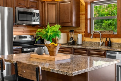Fully equipped chef’s kitchen with granite countertops and bar seating.