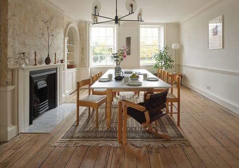 Gather around this elegant marble dining table set for ten, bathed in natural light from grand Georgian windows. The room’s high ceilings, statement chandelier, and characterful original details create a warm, sophisticated space for memorable meals 