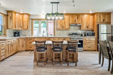 Enjoy meals with a view in this bright dining area featuring large windows, rustic wood accents, and cozy seating for six.