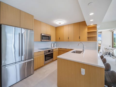 Kitchen - Cook and gather in the Sky Ala Moana kitchen, where stainless steel appliances, long counters, and stylish cabinetry blend function with Honolulu’s contemporary island living.