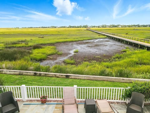 The Osprey Nest • Lounge Seating with Panoramic Marsh View - Take in sweeping views of the coastal marsh from The Osprey Nest’s stone pool terrace—complete with cushioned loungers, shaded seating, and a front-row seat to the tides of Bloody Marsh.