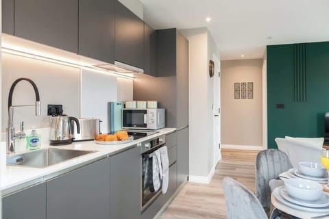 A fully equipped modern kitchen featuring a stove, oven, microwave, toaster, and kettle—perfect for home-cooked meals
