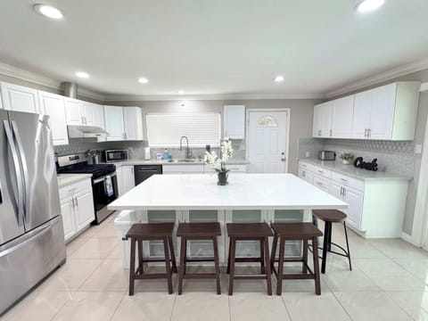 Full kitchen with quartz counter top and mini bar chairs