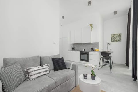 Living area with natural light from large windows, furnished with cozy seating and soft textiles.