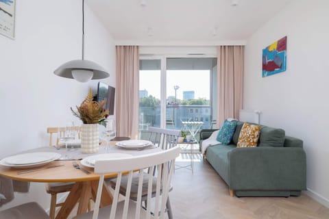 Living room with a sofa bed, dining area and access to the balcony.