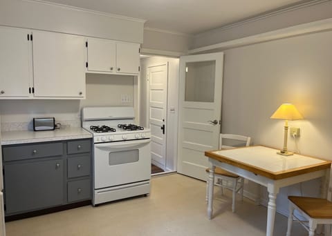 Kitchen with gas stove and additional table.