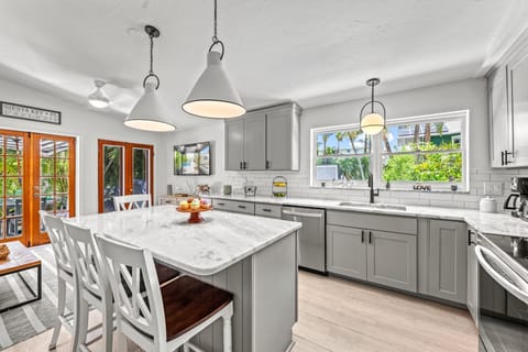 Sunlight pours into the kitchen, where coastal touches and open flow make it a joy to cook and connect.
