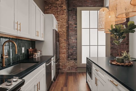 While fully equipped with modern conveniences, the kitchen retains the building’s historic charm with its original exposed brick walls.