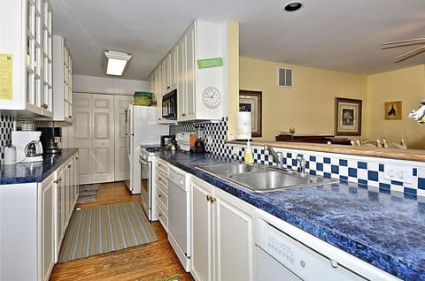 The spacious kitchen features sleek blue countertops, ample cabinetry, and modern appliances, creating a welcoming space for meal preparation.