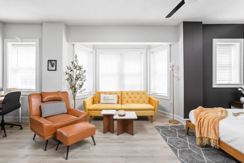 Bask in natural light from the bay windows as you unwind in this thoughtfully styled lounge—complete with a tufted sofa, mid-century chair, and soft accents that make relaxation effortless.