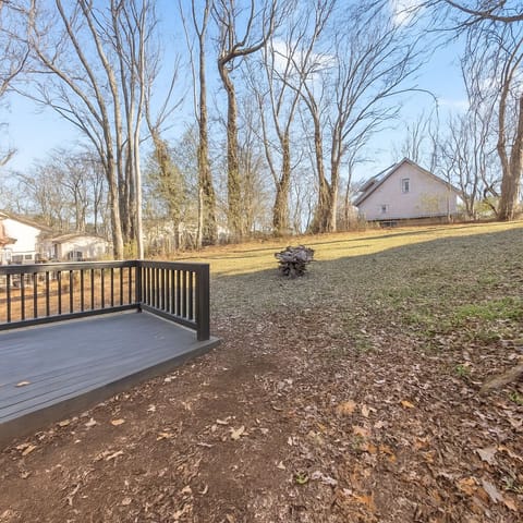Large Backyard With A Deck And Surrounded By Mature Shade Trees.