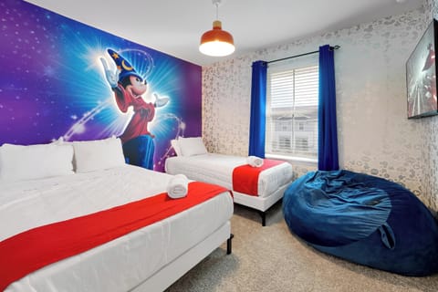 Bedroom 2: Whimsical bedroom with Mickey themed mural, twin beds, and cozy bean bag chair.