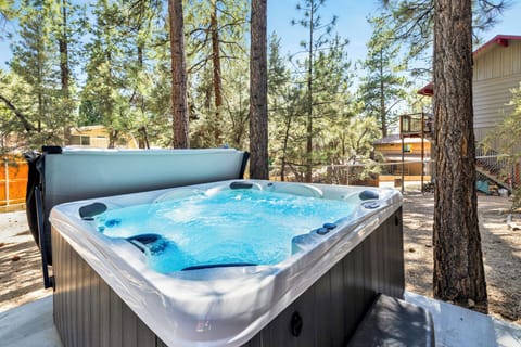 Private outdoor hot tub, surrounded by tall pines, perfect for relaxing under the trees after a day of adventure—enjoy peaceful forest views, fresh air, and a truly rejuvenating stay.
