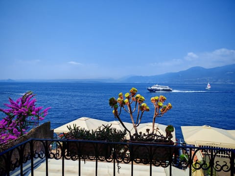 Stunning panoramic view from the terrace of the apartment in Torri del Benaco, overlooking Lake Garda. The flower-filled balcony offers breathtaking views of the lake, with boats and ferries sailing across the water, perfect for relaxing moments and outdoor breakfasts.