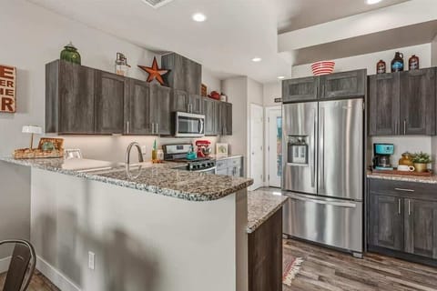The fully equipped kitchen features modern appliances, including a coffee maker, microwave, gas range, oven, dishwasher, fridge, KitchenAid mixer, toaster, and blender—ideal for cooking and packing picnic lunches for a day of adventures!