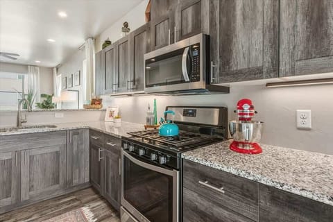 The fully equipped kitchen features modern appliances, including a coffee maker, microwave, gas range, oven, dishwasher, fridge, KitchenAid mixer, toaster, and blender—ideal for cooking and packing picnic lunches for a day of adventures!