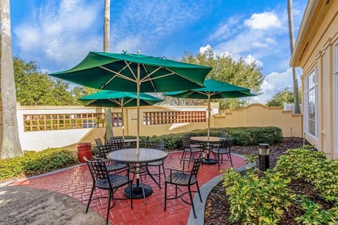 Sip coffee outdoors beneath umbrellas in a peaceful courtyard.