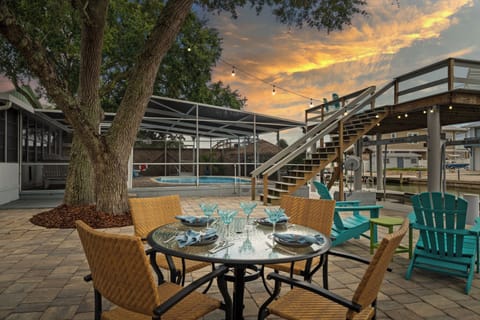 Outdoor area with dining table, lounge chairs, and string lights.