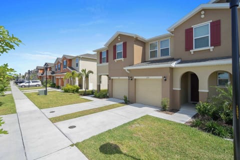 Welcome to this modern townhome on a palm-lined street-private garage, arched entry, and colorful shutters set a relaxing, coastal vibe.