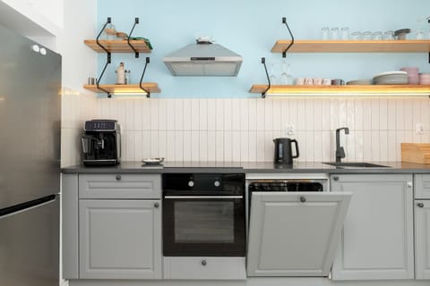 Open kitchen and dining space with blue cabinets and modern appliances.