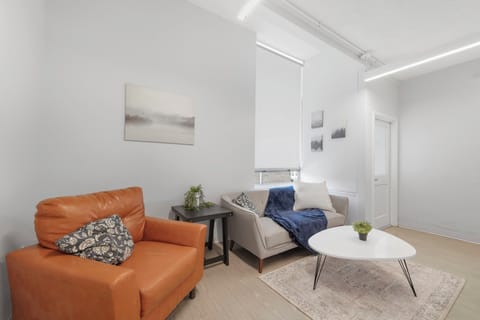Cozy shared lounge w/ loveseat, armchair & soft lighting—great to unwind.