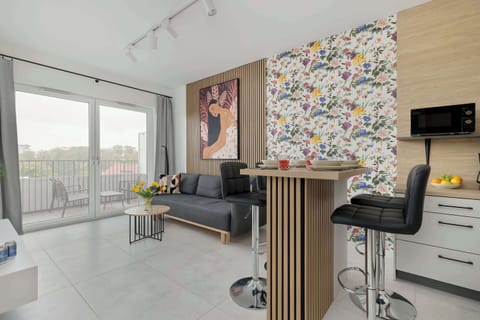 Stylish living room with kitchenette and dining area.