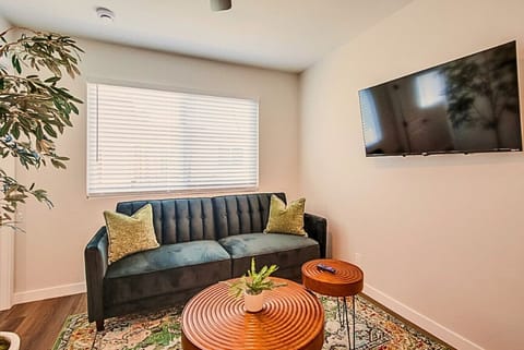 Comfortable seating area with large window and wall-mounted smart TV.