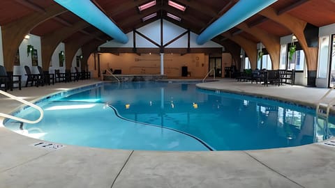 Dive into the serene indoor pool beneath soaring beams.