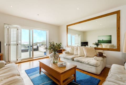 Surfside, Mawgan Porth Newquay: First floor: A gorgeous, bright, and airy living area overlooking stunning coastal views, with the sound of crashing waves in the background. Spacious patio doors open onto the patio, letting you step outside and breathe in