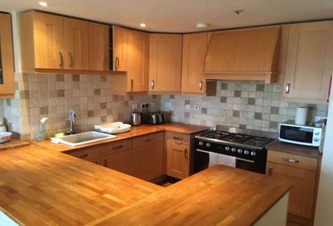 Surfside, Mawgan Porth. First floor: A traditional kitchen with a warm, homely feel, ideal for preparing tasty meals with family or friends.