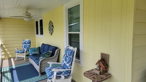 Sweet covered side porch overlooks fenced yard