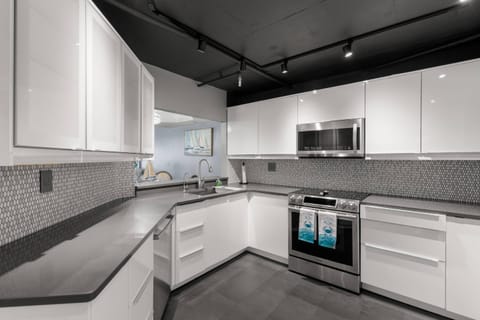 Updated, Fully Equipped Kitchen with Sleek White Cabinets and Stainless-Steel Appliances