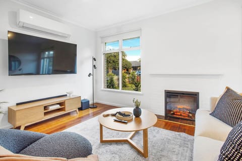 Cozy up in this inviting living room featuring a stylish fireplace 