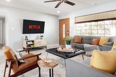 Spacious living room with two sofas, a lounge chair, SmartTV and shuffleboard.