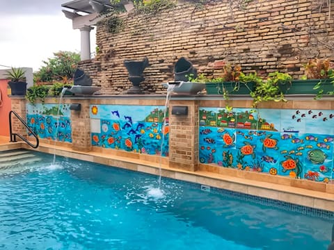 Unwind to cascading waterfalls and vibrant mural poolside.