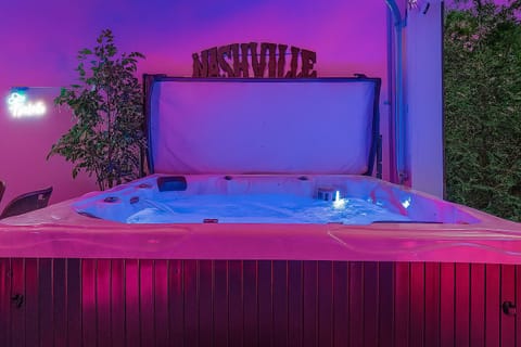 Private indoor hot tub with Nashville-inspired lighting.
