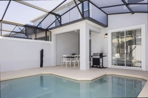 Enjoy poolside paradise with a screened patio, comfy dining set, and BBQ grill-perfect for relaxing and alfresco dining after a day of adventure!