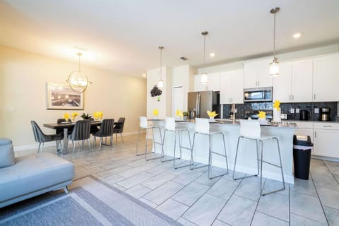 Dine and unwind in this expansive living space featuring a chic kitchen island, contemporary dining table, and cozy lounge-ideal for family feasts and fun.