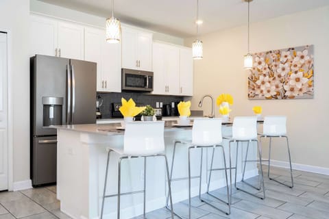 Host family and friends at this spacious kitchen island, perfectly set with stylish stools, pendant lighting, and everything you need for shared meals.
