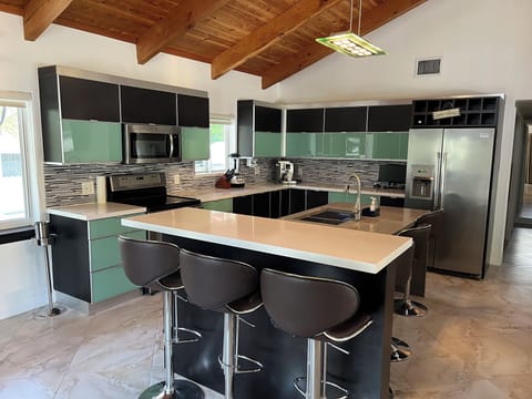Modern kitchen appliances and seating for 6 on the island.